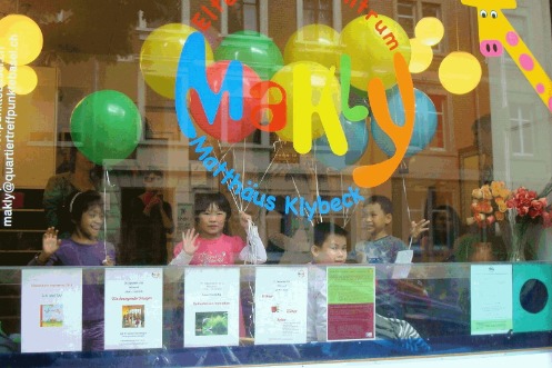 Kleine Kinder schauen von innen aus dem Schaufenster des Quartiertreffpunkts Makly (Copyright Mireille Lingg) 